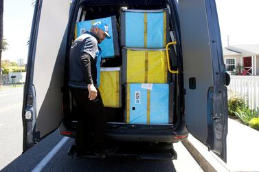 A delivery guy steps down from the back of the van as he makes deliveries for Amazon during the outbreak of the coronavirus in California. Reuters