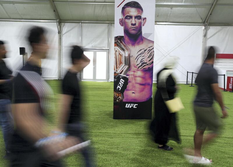 Abu Dhabi, United Arab Emirates - September 06, 2019: Fight fans walk passed a poster of Dustin Poirier at the UFC fan zone. Friday the 6th of September 2019. Yes Island, Abu Dhabi. Chris Whiteoak / The National