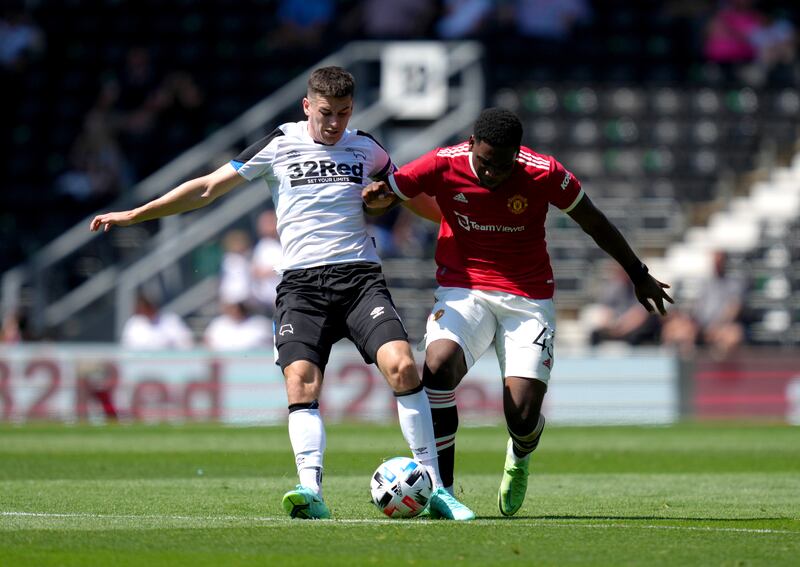 Derby County's Tom Lawrence, left, battles for possession with Teden Mengi of United.