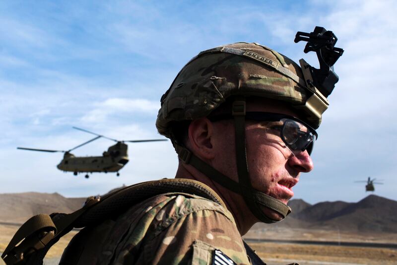 A U.S. soldier from the 3rd Cavalry Regiment waits for a CH-47 Chinook helicopter from the 82nd Combat Aviation Brigade to land after an advising mission at the Afghan National Army headquarters for the 203rd Corps in the Paktia province of Afghanistan December 21, 2014. REUTERS/Lucas Jackson (AFGHANISTAN - Tags: CIVIL UNREST POLITICS MILITARY TPX IMAGES OF THE DAY) - RTR4IUNB