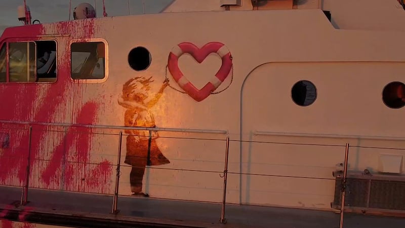 The vessel bears a Banksy artwork showing a girl in a life vest with a heart-shaped buoy. MV Louise Michel via Reuters