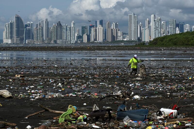 A man collects garbage, including plastic waste, at the beach of Costa del Este, in Panama City. AFP