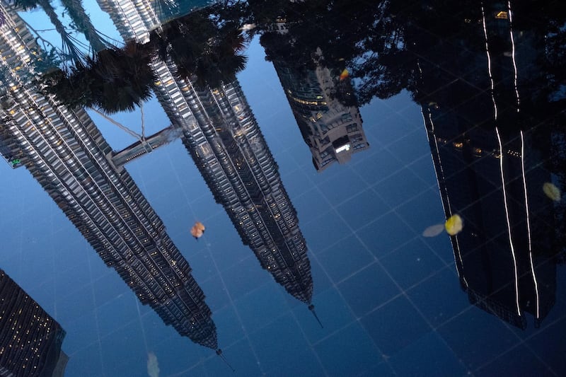 The Petronas Twin Towers are reflected in a pool at dawn in Kuala Lumpur, Malaysia. Bloomberg