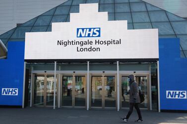 A man wearing a face mask walks past the entrance of the temporary NHS Nightingale Hospital at the Excel Centre in London, Britain, 27 March 2020.  EPA