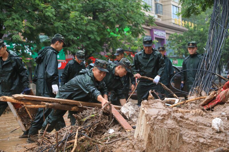 Paramilitary police officers clear debris from a street in Gongyi, Henan province.