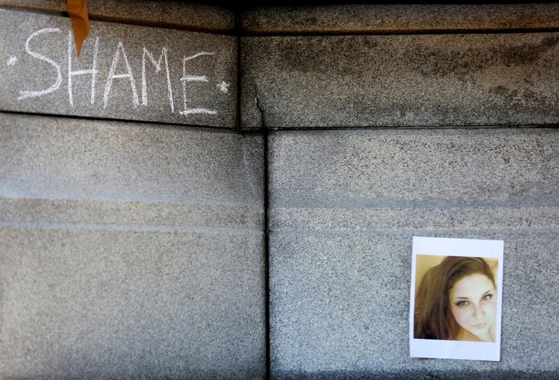 The word "SHAME" is written on the Confederate monument near a photograph of Heather D. Heyer, the woman who was killed Saturday in Charlottesville, Va., during the protest in downtown Norfolk, Va., on Wednesday, Aug. 16, 2017. (Steve Earley/The Virginian-Pilot via AP)