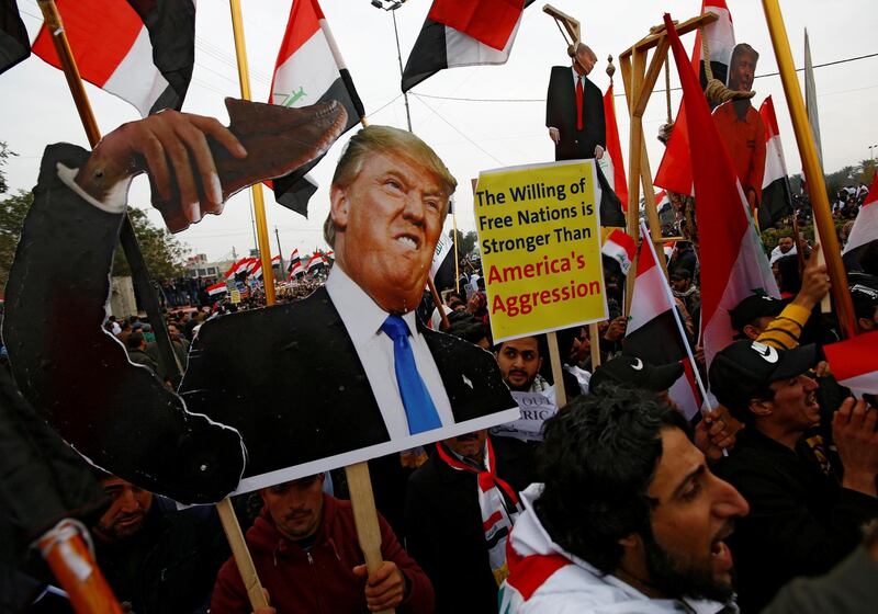 Supporters of Iraqi Shiite cleric Moqtada Al Sadr carry placards depicting US President Donald Trump at a protest. Reuters