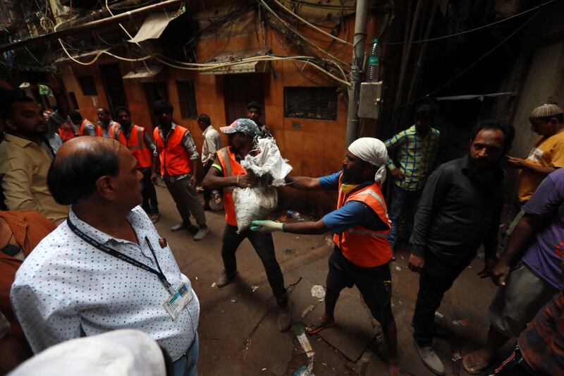 Municipal workers clear the debris from the site of collapsed building. EPA