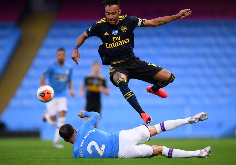 Arsenal's Gabonese striker Pierre-Emerick Aubameyang hurdles a challenge from Manchester City's English defender Kyle Walker. AFP