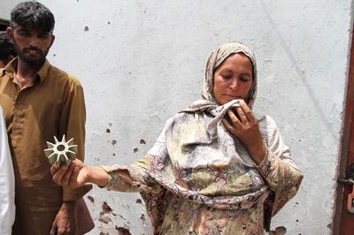 A Pakistani villager holds remains of a shell allegedly fired by Indian troops in Khanoor Mian, along the Line of Control in Pakistan, Friday, May 18, 2018. Pakistani military accused Indian troops of initiating an "unprovoked" violation of the 2003 cease-fire accord between the two countries along the frontier near Kashmir and targeting the civilian population, including scores of villagers who died Friday morning. (AP Photo/Shahid Ikram)