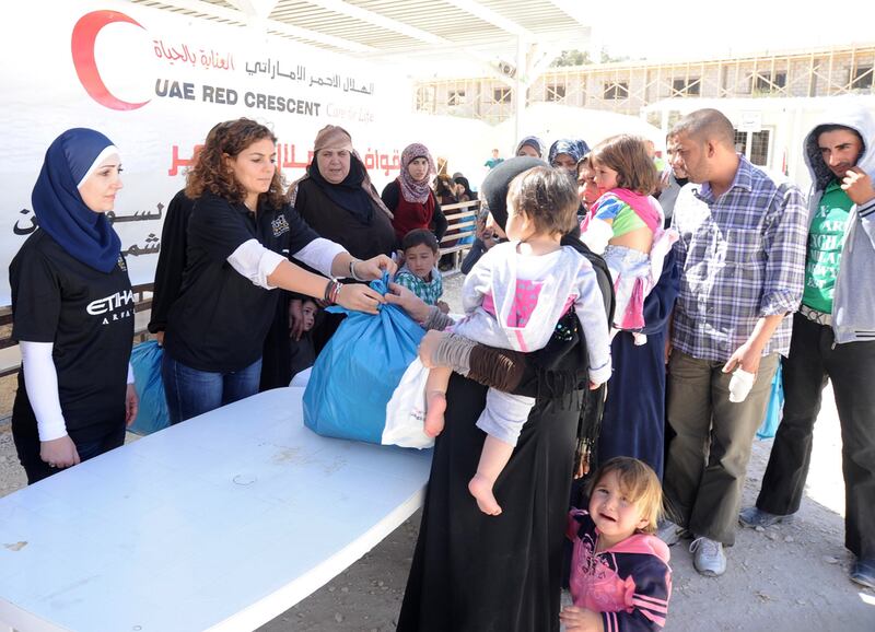 Staff from Etihad Airways distribute more than 2,000 blankets and relief items to refugees at the Emirati-Jordanian Field Hospital in Al Mafraq. They and Red Crescent volunteers also visited the Mrajeeb Al Fhood camp. Courtesy Etihad  