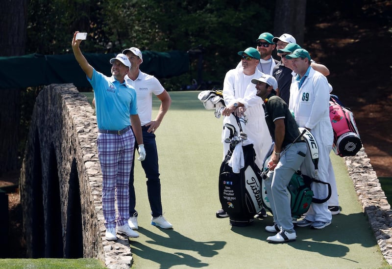 England's Ian Poulter takes a selfie with Sweden's Henrik Stenson, Max Homa of the US, England's Matt Wallace and caddies on the Hogan Bridge on the 12th hole at Augusta National Golf Club during a practice round at The Masters. Reuters