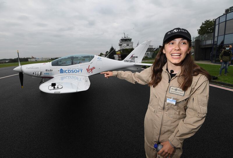Zara Rutherford poses in front of her microlight jet before taking off on her round-the-world trip. AFP