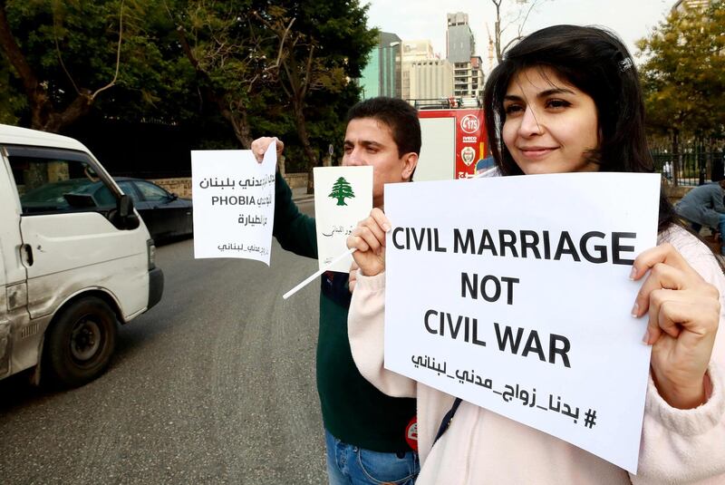 Lebanese demonstrators carry placards during a gathering against the ongoing ban on civil unions outside the Ministry of Interior in the capital Beirut on February 23, 2019.  / AFP / ANWAR AMRO
