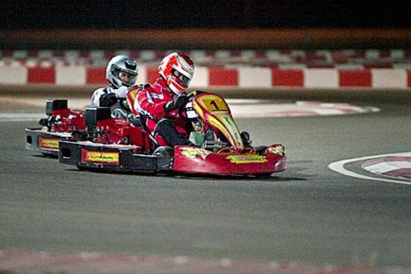 An amateur kart driver grabs the wheel during the qualifying heats in Al Ain.