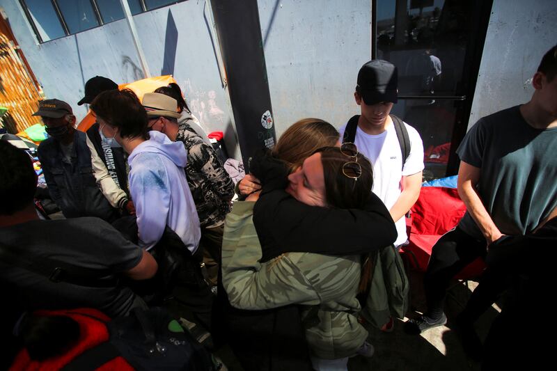 A Russian and a Ukrainian embracing at the San Ysidro Port of Entry of the US-Mexico border in Tijuana, Mexico. Reuters