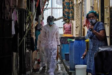 A worker from Bharatiya Jain Sanghatana, a non-governmental organisation, walks in an alley to screen the residents during a check-up campaign for the coronavirus disease (COVID-19) in a slum Mumbai, India, July 23, 2020. Reuters