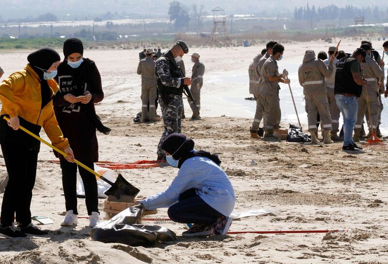 Young volunteers clean a contaminated beach in the southern Lebanese city of Tyre.  AFP