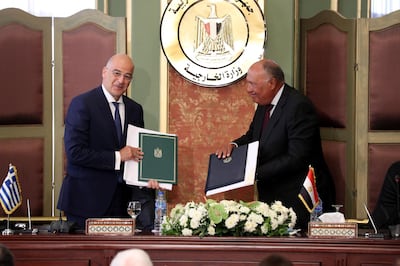 epa08587694 Greek Foreign Minister Nikos Dendias (L) and Egyptian Foreign Minister Sameh Shoukry (R) hold up signed documents after signing maritime border agreement in Cairo, Egypt, 06 August 2020. Egypt and Greece on 06 August signed an agreement to demarcate the maritime borders between the two countries.  EPA/KHALED ELFIQI