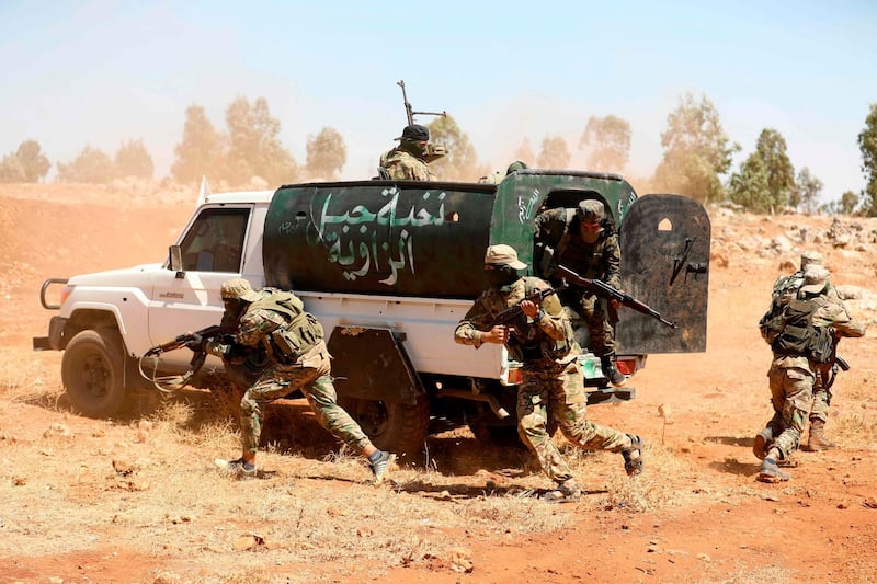 (FILES) In this file photo taken on August 14, 2018 Syrian fighters attend a mock battle in anticipation of an attack by the regime on Idlib province and the surrounding countryside, during a graduation of new Hayat Tahrir al-Sham (HTS) members at a camp in the countryside of the northern Idlib province. The main jihadist alliance in Syria's Idlib region reached a deal on January 10, 2019 ending days of deadly fighting with rival rebels and extending its influence over the whole rebel enclave. The agreement brings an immediate end to the fighting between Hayat Tahrir al-Sham (HTS), led by Al-Qaeda's former Syria affiliate, and the rival Turkish-backed National Liberation Front (NLF), according to the jihadists' propaganda website Ebaa.
 / AFP / OMAR HAJ KADOUR
