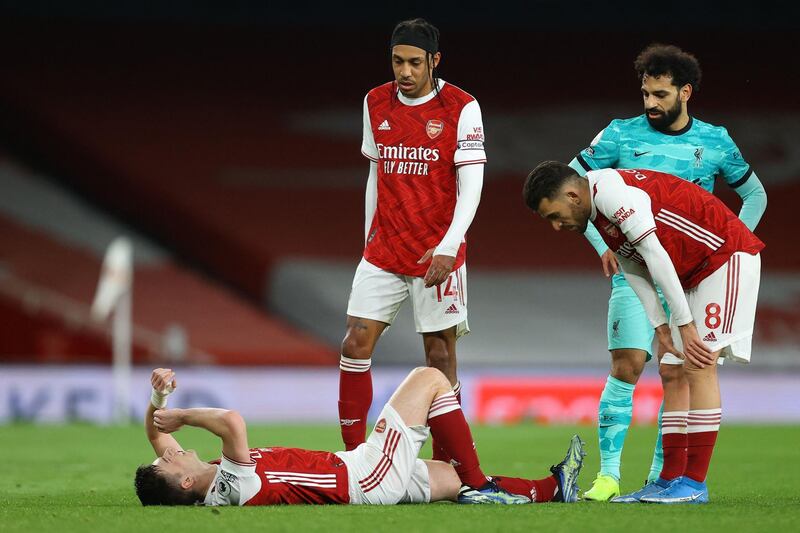 Arsenal's Scottish defender Kieran Tierney (L) lies injured during the English Premier League football match between Arsenal and Liverpool at the Emirates Stadium in London on April 3, 2021.   - RESTRICTED TO EDITORIAL USE. No use with unauthorized audio, video, data, fixture lists, club/league logos or 'live' services. Online in-match use limited to 120 images. An additional 40 images may be used in extra time. No video emulation. Social media in-match use limited to 120 images. An additional 40 images may be used in extra time. No use in betting publications, games or single club/league/player publications.
 / AFP / POOL / Julian Finney / RESTRICTED TO EDITORIAL USE. No use with unauthorized audio, video, data, fixture lists, club/league logos or 'live' services. Online in-match use limited to 120 images. An additional 40 images may be used in extra time. No video emulation. Social media in-match use limited to 120 images. An additional 40 images may be used in extra time. No use in betting publications, games or single club/league/player publications.
