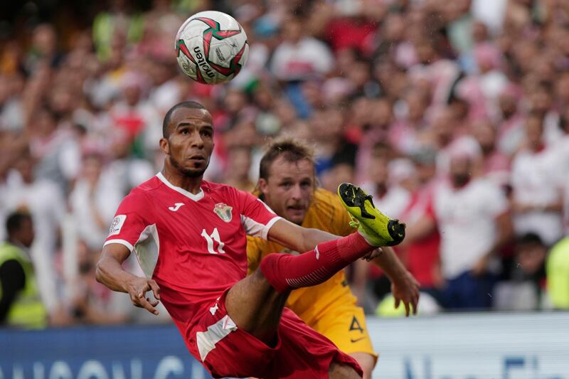Jordan midfielder Yasen Al Bakhet, left, fights for the ball with Australia defender Ryan Grant.  AP Photo