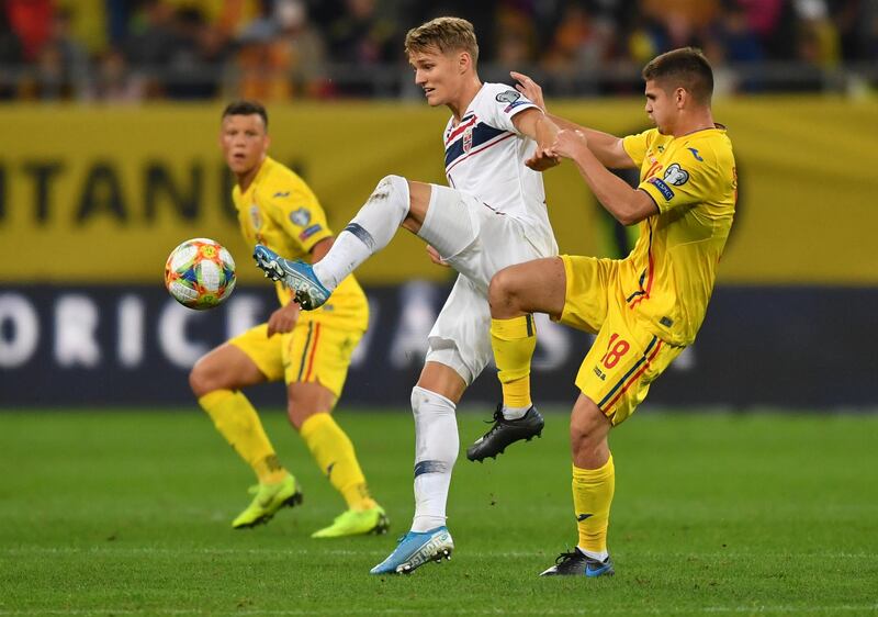 Norway's midfielder Martin Odegaard (C) vies for the ball with Romania's midfielder Razvan Marin (R) during the Euro 2020 Group F qualification football match Romania v Norway in Bucharest, Romania, on October 15, 2019. (Photo by Daniel MIHAILESCU / AFP)