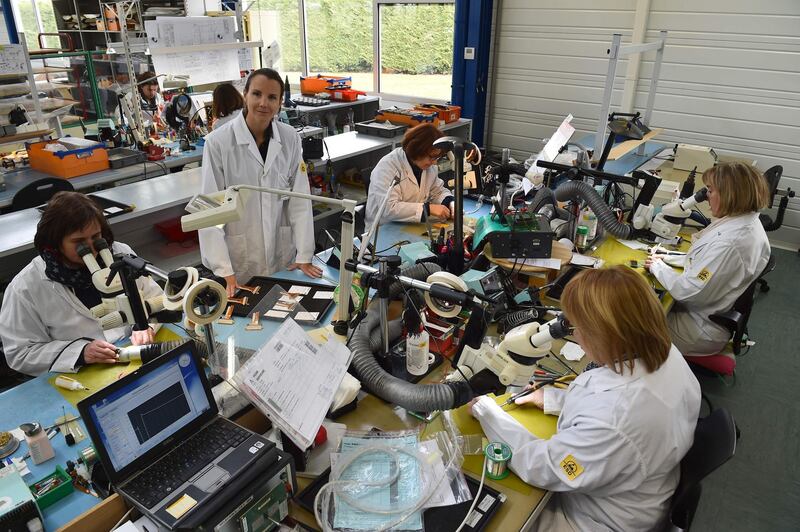 TO GO WITH AFP STORY BY Yves BOITEAU
Anne-Charlotte Fredenucci, President of the Ametra Group, poses for a photograph alongside his employees assembling medical equipment in the Anjou Electronics factory on February 28, 2018, in Longue-Jumelles, western France.
Ariane Espace, Dassault, Thales Communication, Matra, Liebherr-Aerospace ... In Longué-Jumelles, north of Saumur, workers of Anjou Electronics workshop have been assembling, connecting and testing cable assemblies and electronic systems for forty years, designed custom-made for the biggest companies in the aerospace, defense and rail industries. / AFP PHOTO / JEAN-FRANCOIS MONIER