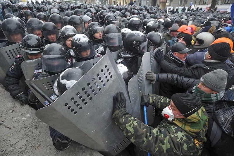 epa04036263 Protesters clash with riot police during an anti-government protest in downtown Kiev, Ukraine, 22 January 2014. Two protesters have died during violent clashes with police in Kiev, Ukrainian opposition activists said 22 January 2014. The police have confirmed only one death so far. Forensic experts are examining the body of a dead man who was lying at a first aid location set up by the protesters, the Ukrainian Interior Ministry said.  EPA/ALEXEY FURMAN