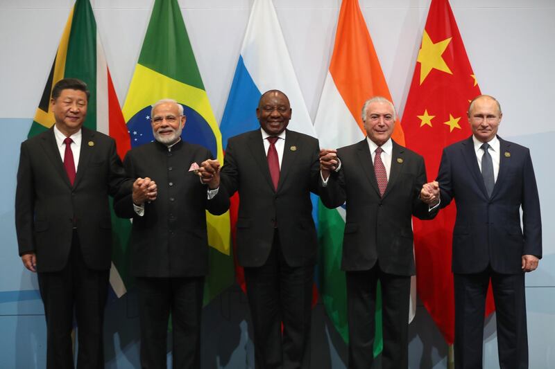 epa06911010 China's President Xi Jinping (L) India Prime Minister Narendra Modi (2-L) South Africa's President Cyril Ramaphosa (C) Brazil President Michel Temer (2-R) and President Vladimir Putin (R), hold hands during the BRICS Summit 'family photo' held in Johannesburg, South Africa, 26 July 2018. The summit is held over three days and ends on 27 July.  EPA/MIKE HTUCHINGS / POOL