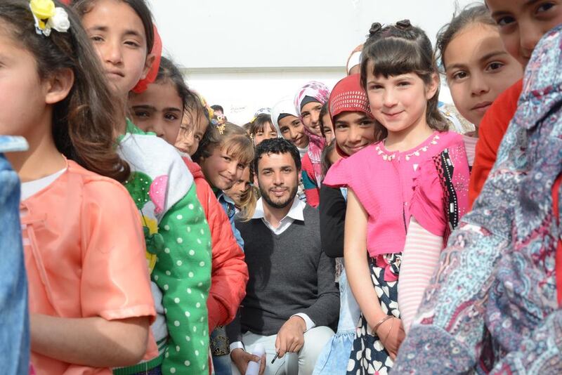 Surrounded by his students, Ghasan Al Hasan, a refugee who escaped Homs four years ago teaches grades 3 to 7 to more than 400 students in the  UAE-Jordanian camp and even gives seminars in Al Zaatari camps to teachers. Naser Al Wasmi / The National