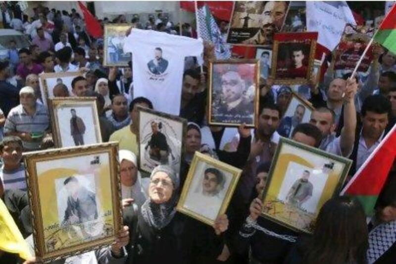 Palestinians in the West Bank city of Nablus hold photographs of prisoners jailed in Israel, during a rally to mark the annual prisoners' day yesterday.