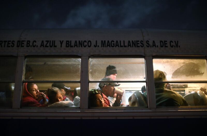 Migrants depart on a bus on their way to a new shelter on the eastern side of Tijuana. Getty Images