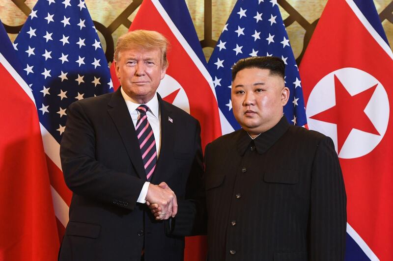 Donald Trump shakes hands with Kim Jong-un. AFP