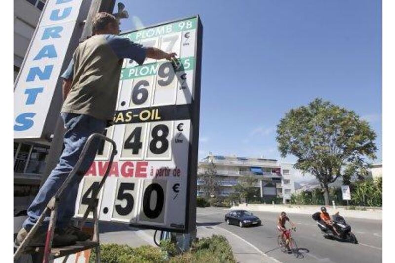 An employee changes fuel prices at a petrol station in Nice, France. François Hollande's government is coming under pressure to equalise petrol and diesel prices. Sebastien Nogier / EPA