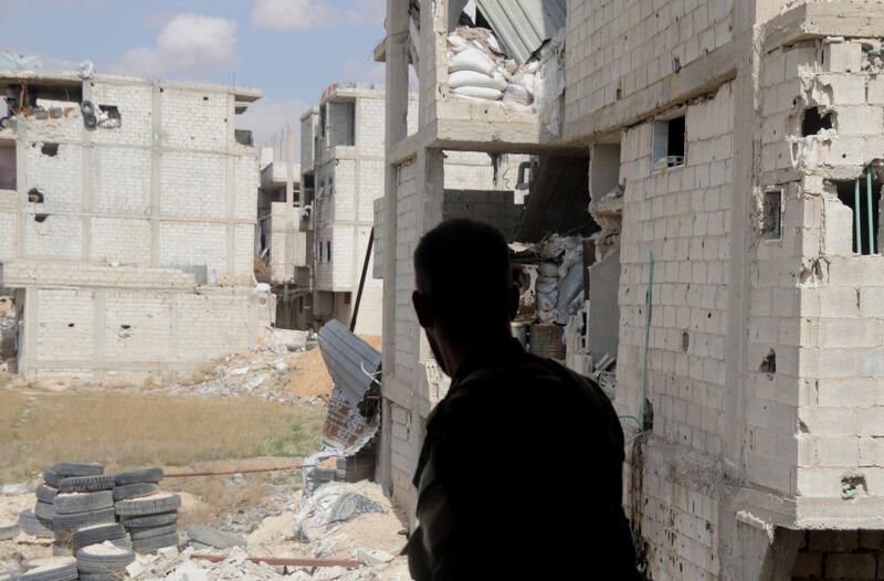 A Syrian government soldier stands near damaged buildings of the besieged rebel-held Eastern Ghouta on February 28, 2018. Youssef Badawi / EPA