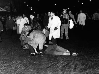 People help protesters injured in clashes with police during a demonstration against the war in Algeria on February 8, 1962. AFP