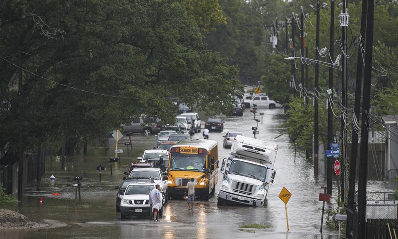 A man tries to direct a school bus on the flooded Hopper Rd. on September 19, 2019 in Houston, Texas. Getty
