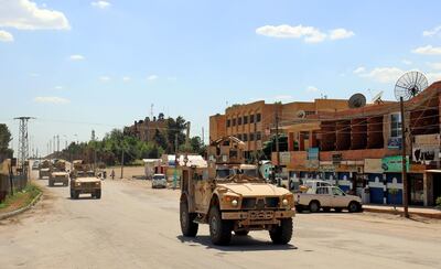 Vehicles from the US-led coalition battling the Islamic State group patrol the town of Rmelane in Syria's Hasakeh province on June 5, 2018. The leading Syrian Kurdish militia said it would withdraw from Manbij, easing fears of a direct clash between NATO allies Washington and Ankara over the strategic northern town. Manbij is a Sunni Arab-majority town that lies just 30 kilometres (19 miles) south of the Turkish border, and where US and French troops belonging to the Western coalition against IS are stationed.  / AFP / Delil souleiman
