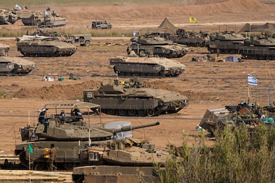 Israeli soldiers by their tanks in a staging area near the border with the Gaza Strip in southern Israel on Tuesday. AP