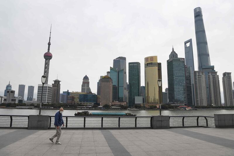 A man wearing a protective face mask walks along the usually busy Bund waterfront along the Huangpu River overlooking Shanghai’s financial district. AFP