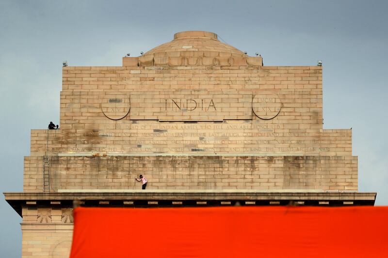 Indian men prepare to illuminate the India Gate. Tsering Topgyal / AP Photo