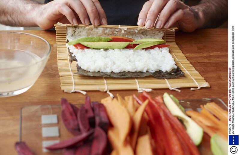 Mandatory Credit: Photo by REX Shutterstock (4463177a)
MODEL RELEASED Man rolling sushi with a sweet potato, avocado and bell pepper filling
VARIOUS

 *** Local Caption ***  hl23ap-food-travel-1.jpg