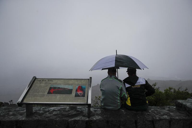 A couple sits on the edge of the Jaggar Museum's overlook to view Kilauea's summit crater in Volcanoes National Park, Hawaii. Jae C Hong / AP Photo