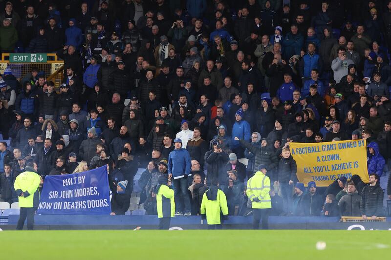 Everton fans hold up banners in protest against the club's board following the defeat. Getty