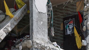 Flags of the Palestinian political party Fatah and a poster of its later leader Yasser Arafat, are placed in the debris of a building destroyed during Israeli bombardment, in Nuseirat, Gaza. AFP