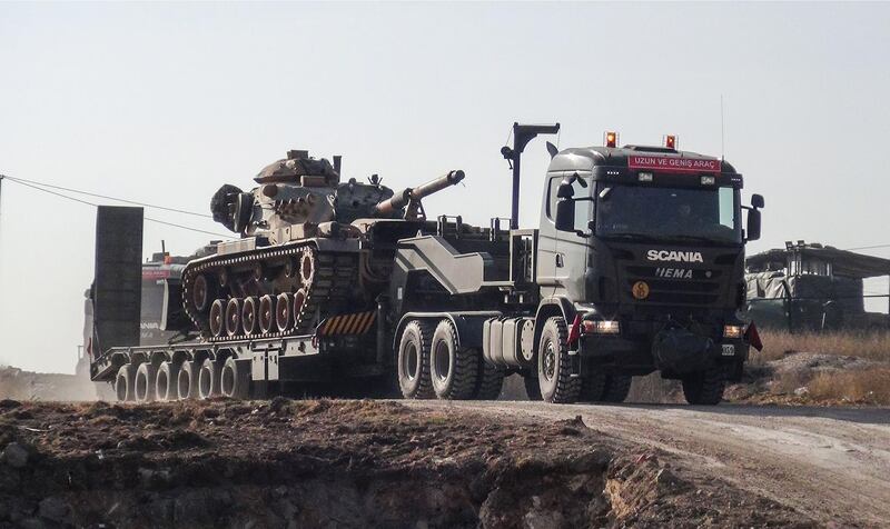 A photo made available by the Dogan New Agency shows Turkish army military trucks transporting armoured vehicles to reinforce the border units in Sanliurfa close to the Syrian border on January 16, 2018.  / AFP PHOTO / DHA / DHA / Turkey OUT