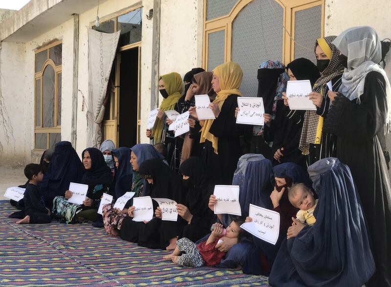 A file photo of Afghan women hold placards reading in Dari 'A Muslim can't go against women's education and work', during a protest as they demand their right to education and work in Mazar-e-Sharif, Afghanistan. EPA / STR