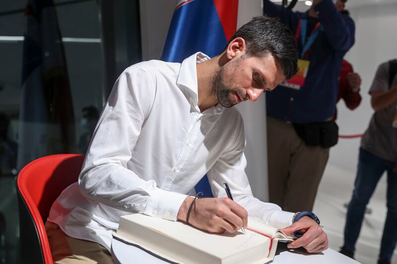 Novak Djokovic writes a message at the Serbian pavilion at Expo 2020 Dubai. Khushnum Bhandari / The National