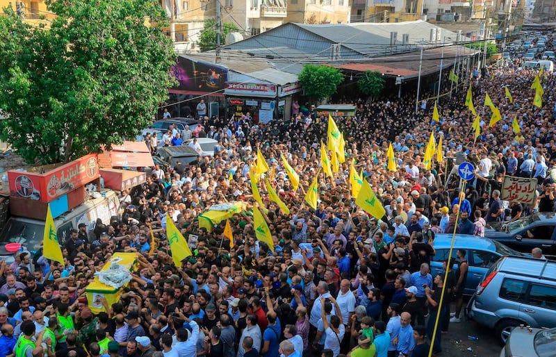 Hezbollah supporters carry the coffin of two fighters during the funeral in the Ghobeiry neighbourhood of southern Beirut on August 26, 2019. AFP